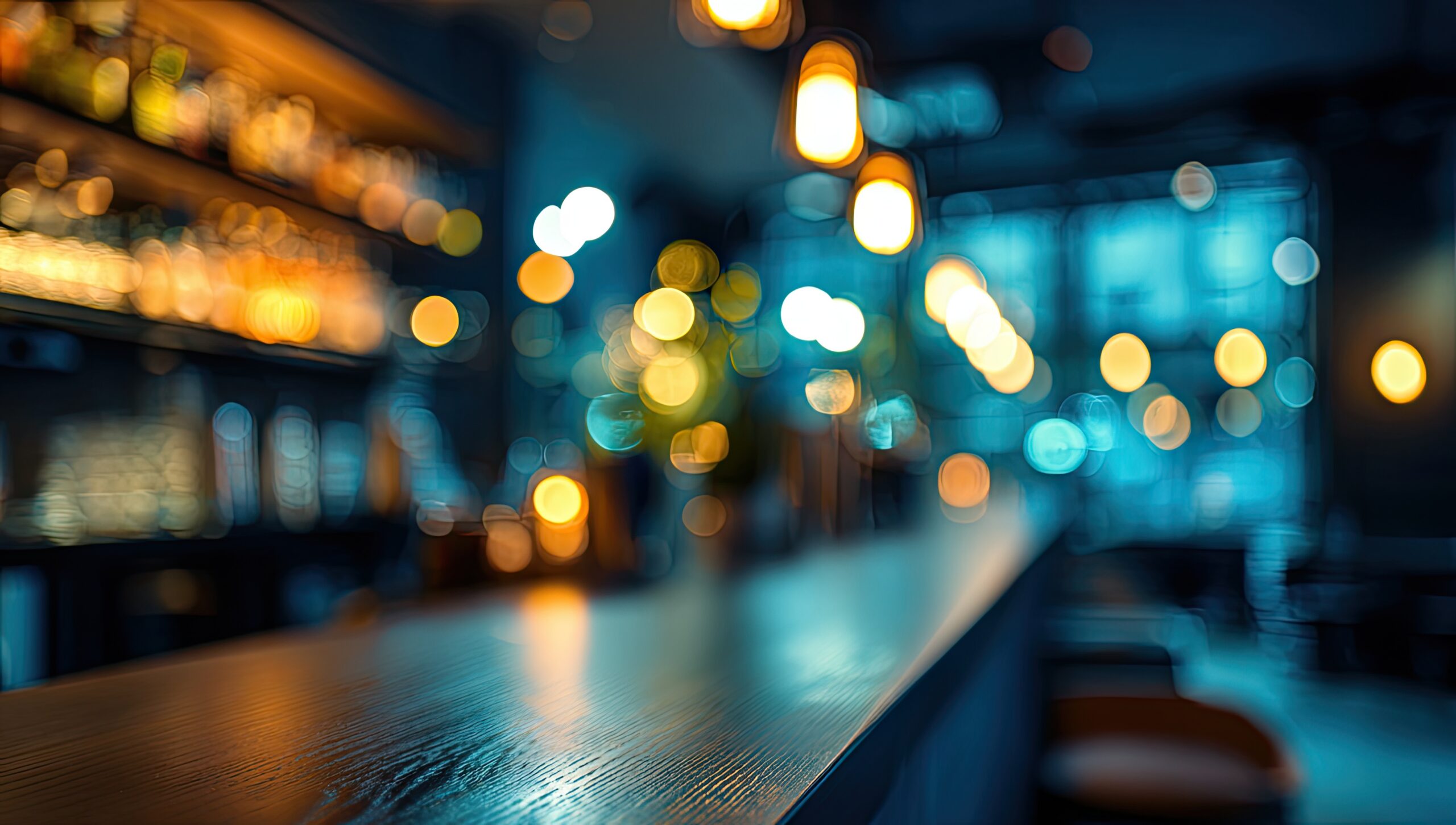 Cozy bar interior with warm lights and blurred bottles on shelves.